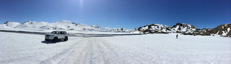 4x4 vehicle on snowy mountain terrain under clear blue sky, perfect for adventure and exploration.