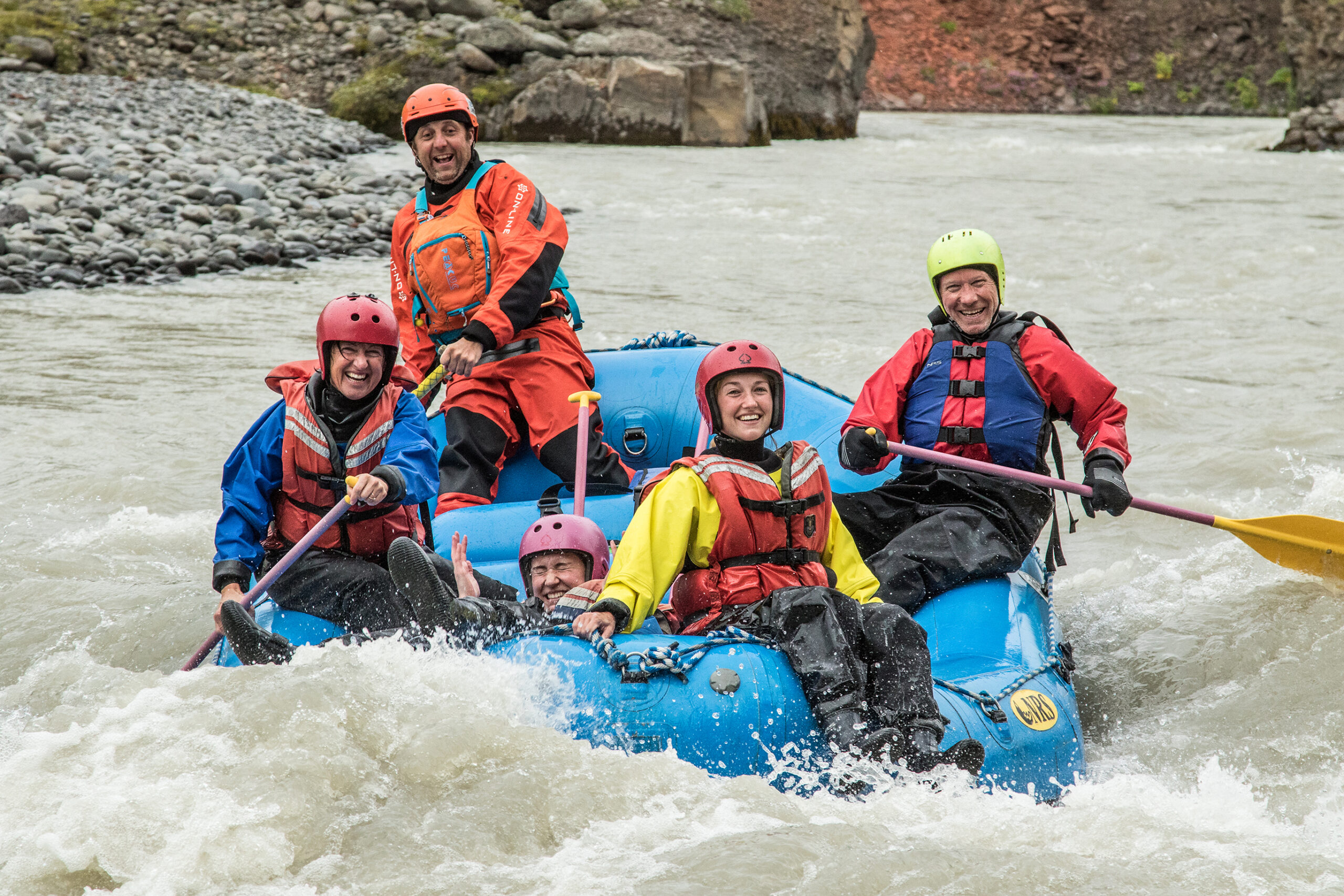 Group enjoying an exhilarating white-water rafting adventure on a rocky river.