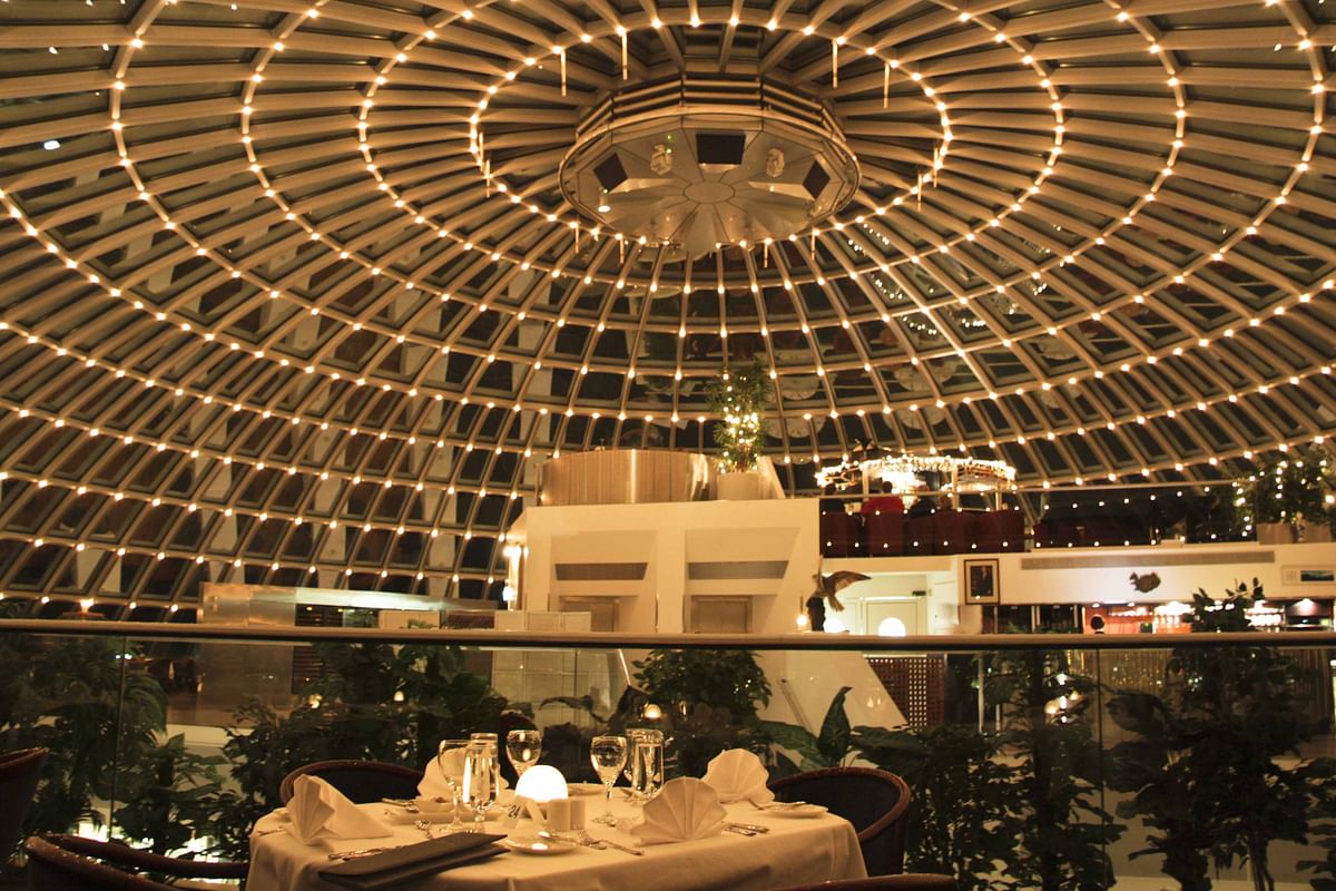 Elegant restaurant under a domed ceiling with ambient lighting and a set dining table.