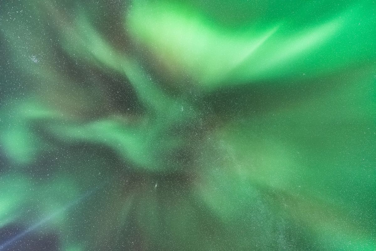 Aurora borealis with vibrant green hues and starry sky, creating a mesmerizing natural light display at night.