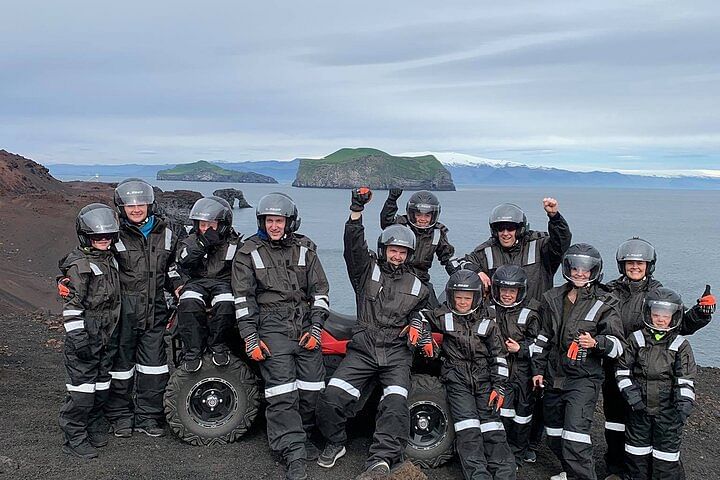 ATV group adventure on a rocky coastline with scenic ocean backdrop and distant islands.