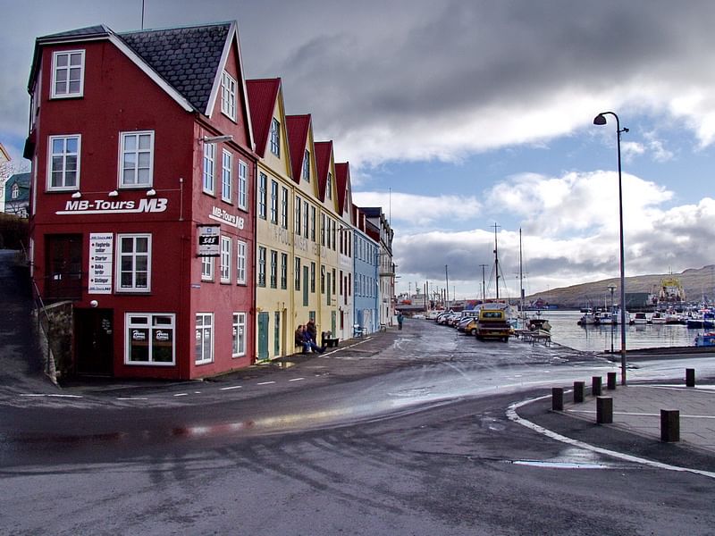 Colorful buildings by a harbor under a cloudy sky, Tórshavn, Faroe Islands.