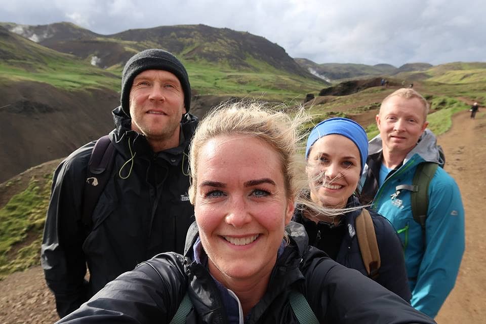 Group hiking in scenic mountains, enjoying nature and adventure. Smiling friends taking a selfie on a trail.