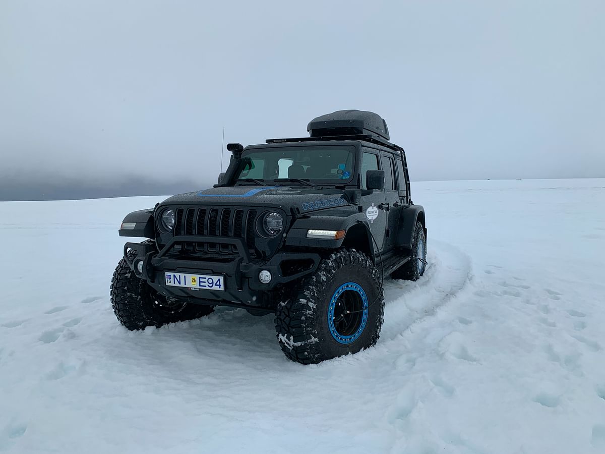 Off-road vehicle navigating snowy terrain under an overcast sky.